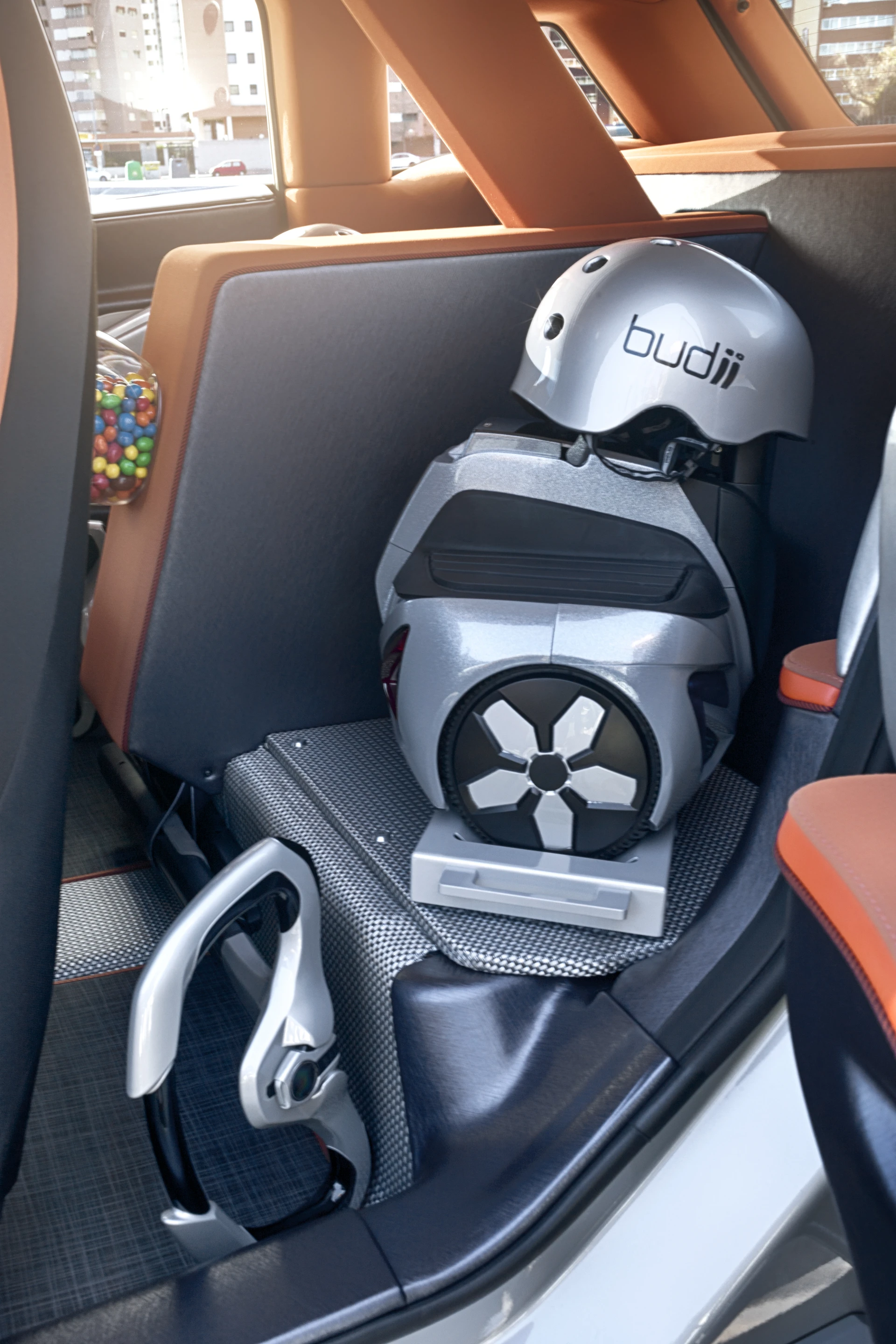 Two electric mini vehicles that are housed in roll-out draw pods on either side of the car
