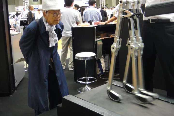 A curious observer watches the biped walk on a treadmill (Photo: Diginfo.tv)