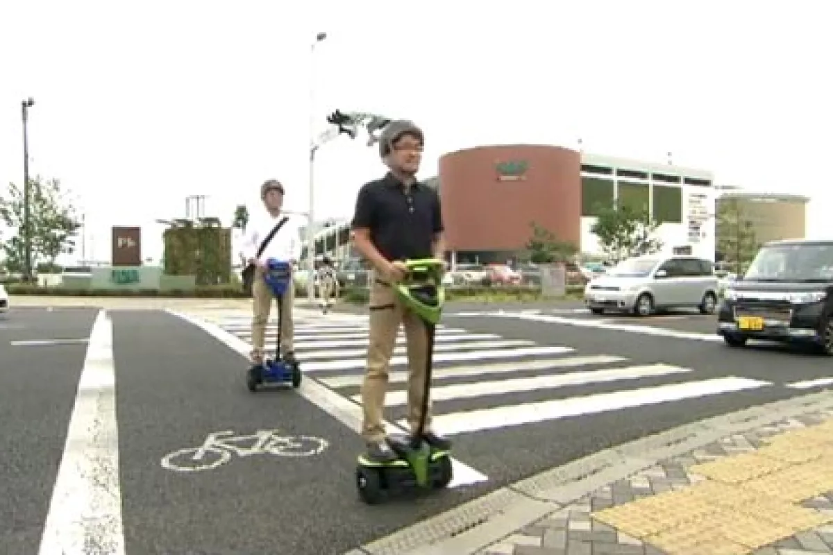 Test subjects ride the Toyota Winglet personal mobility robot on public sidewalks and road crossings in Japan