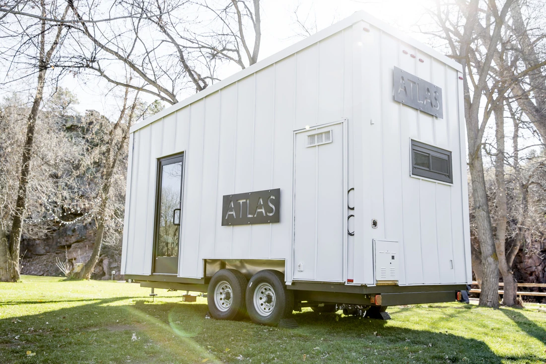 While in transit, the trailer-based home's deck and lift-up awning are folded shut