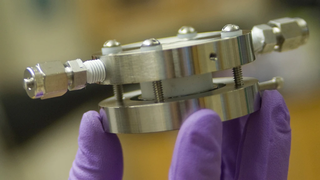 An experimental lithium-air battery developed at MIT has inlet and outlet on the sides to provide a flow of air, providing oxygen for the battery's operation (Image: Patrick Gillooly/MIT)