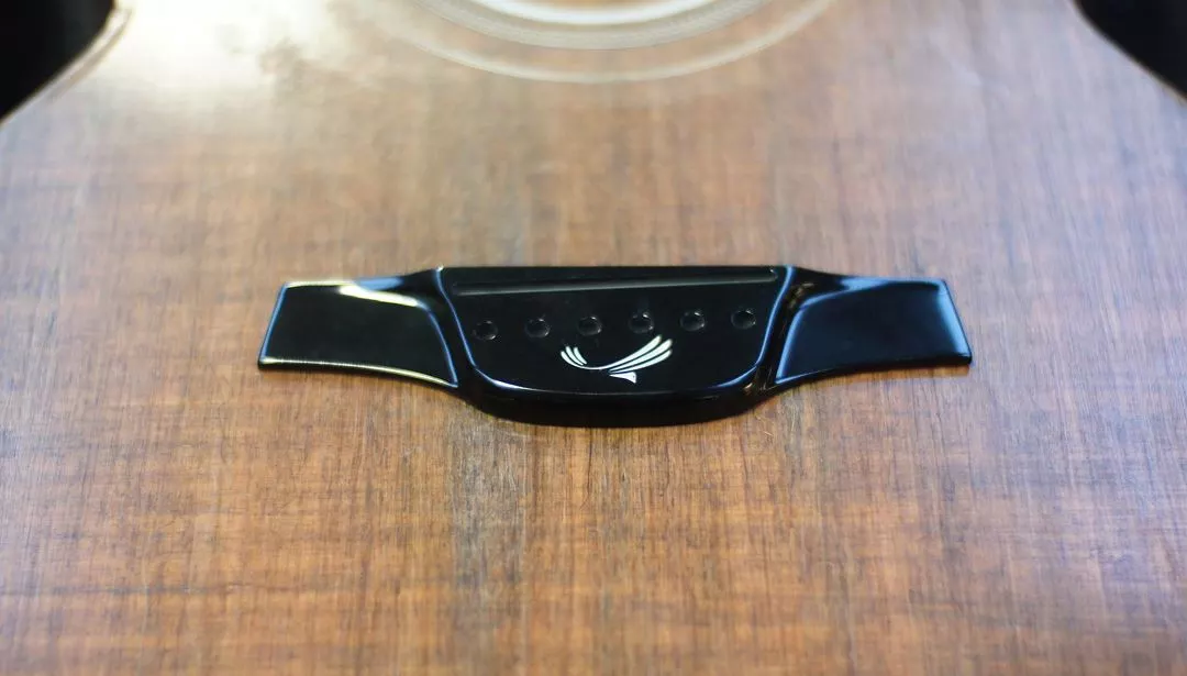 El Capitan has a HPL (high pressure laminate) bridge and Graphtech saddle