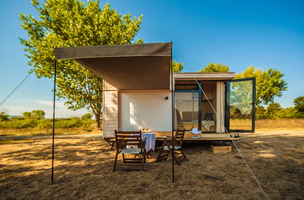 Hristova added a removable awning/canopy, a small decking area, and a collapsible bench and outdoor kitchen setup