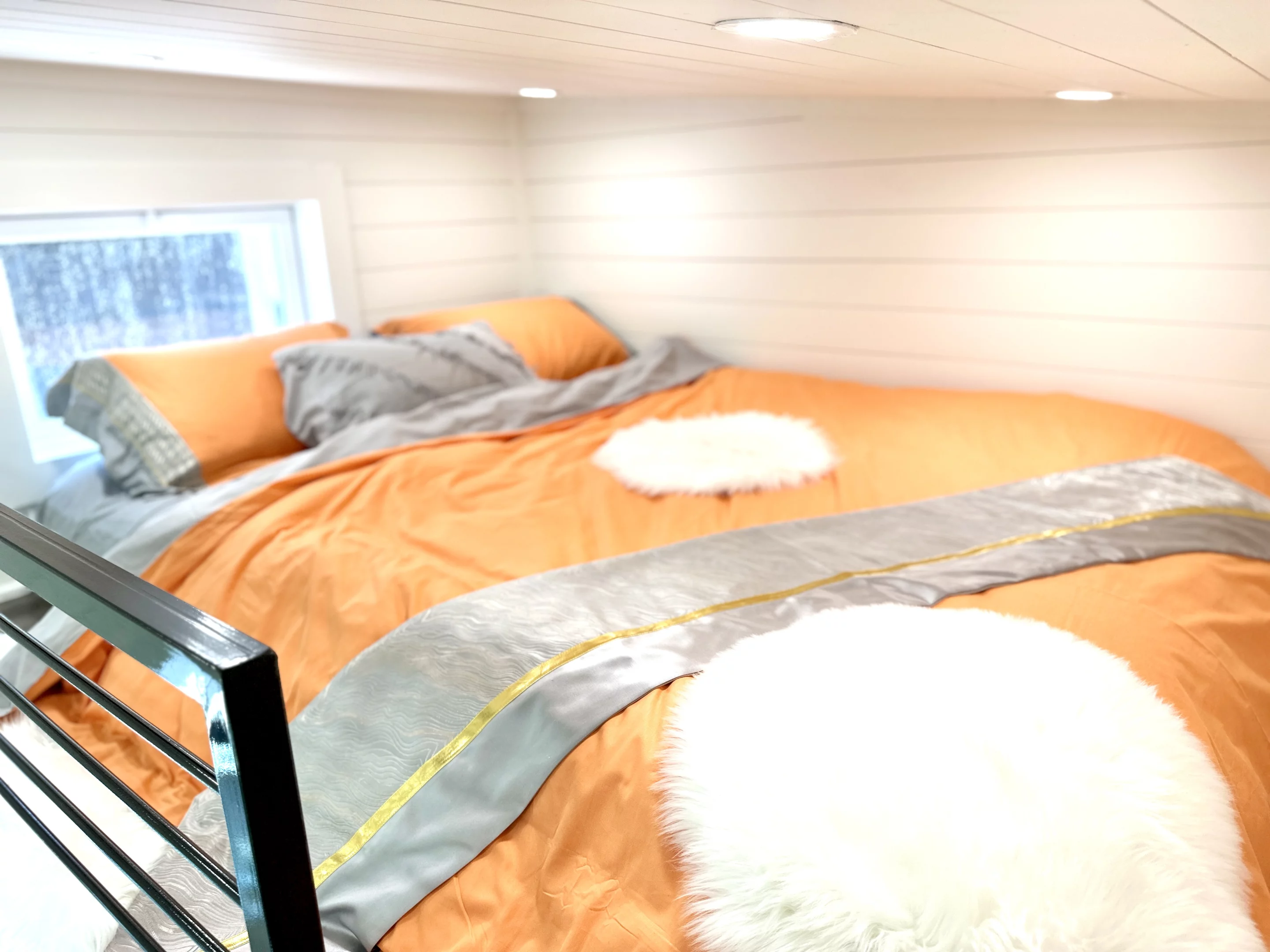 The 16' THOW With Loft's bedroom features a low ceiling and has enough space for a double bed