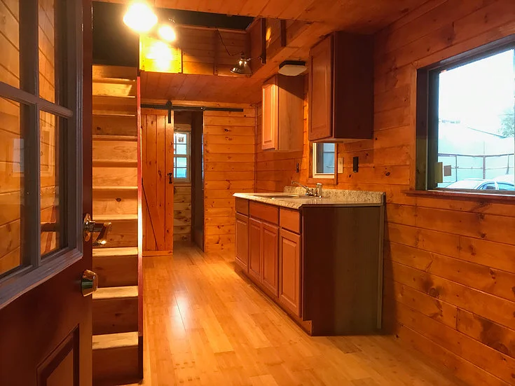 The Devasa's interior includes a snug living room area a kitchen, and a bathroom