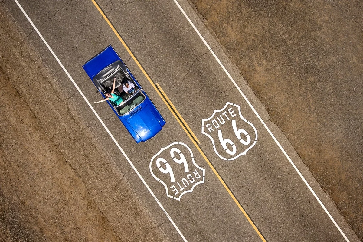 A Ford Mustang carries a couple down Route 66 in the US