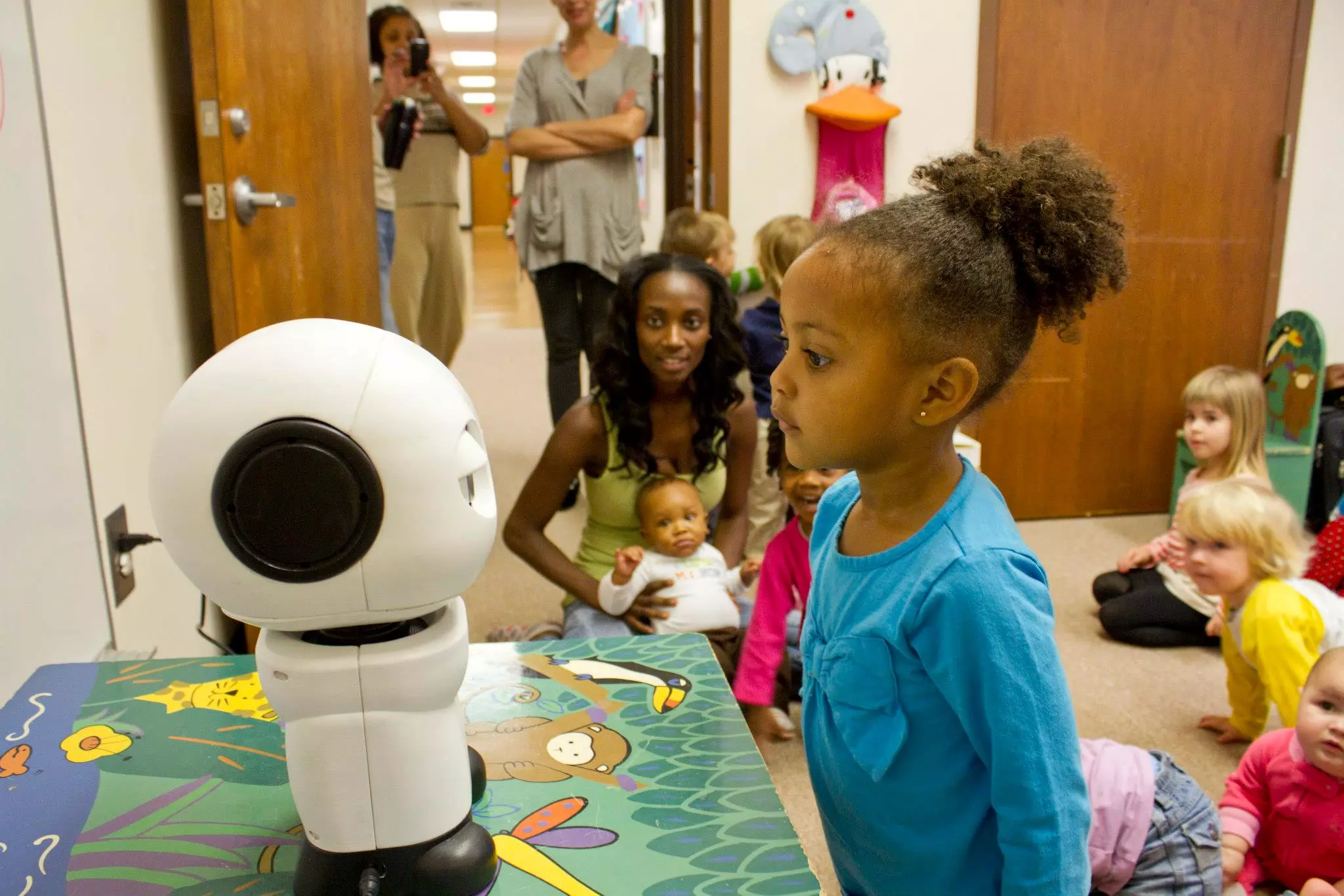 Children interact with Hello Robo's communication robot, MAKI