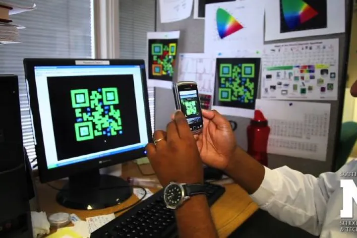 An AutoCAD rendering of one of the QR codes, being read by a smartphone
