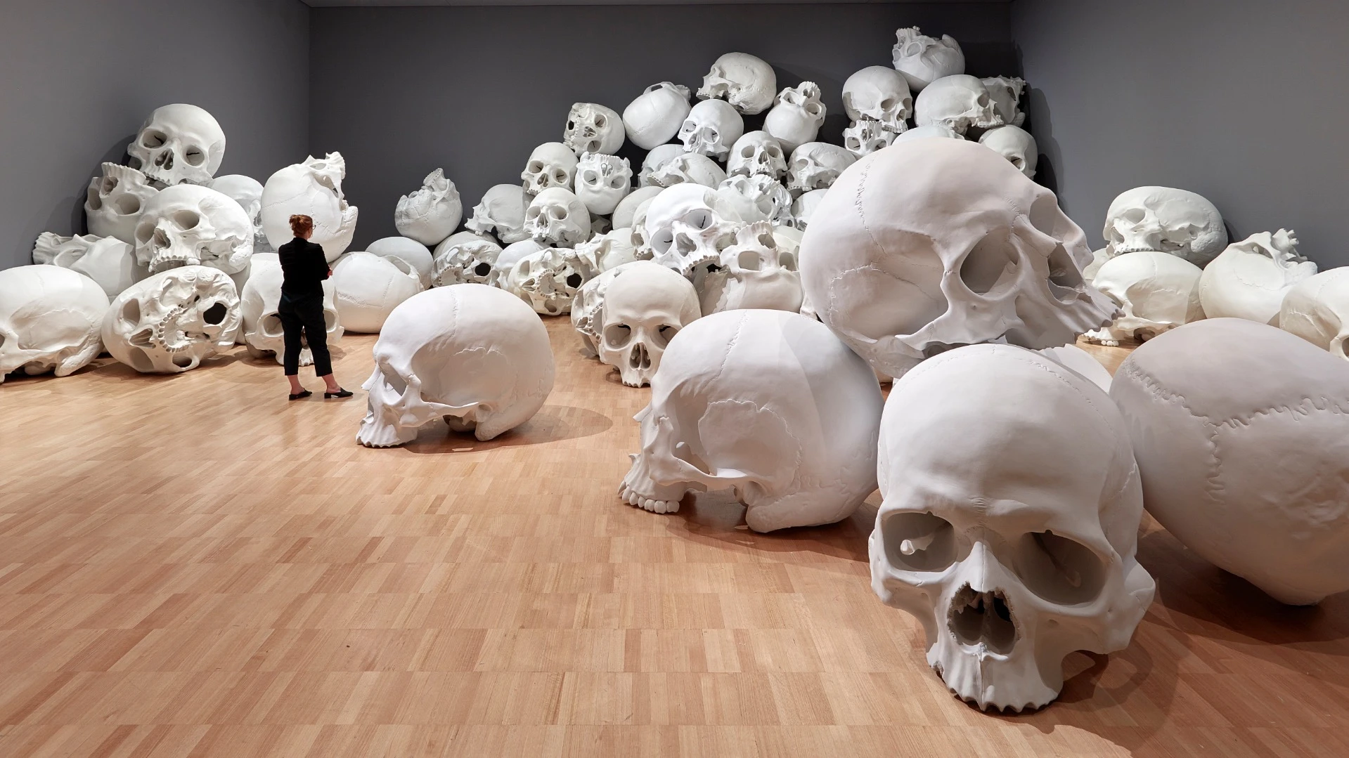 Ron Mueck's huge installation features 100 giant skulls strewn around the gallery's classic art collection