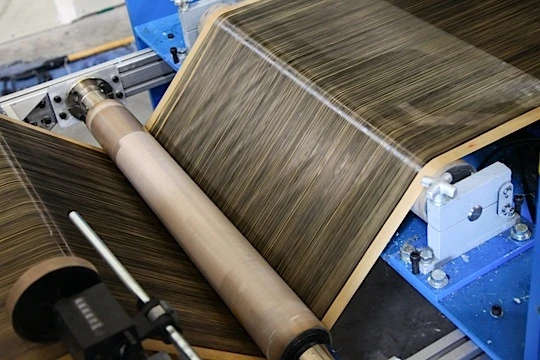 Fibers on backing paper are dried, rolled and cut into narrower widths