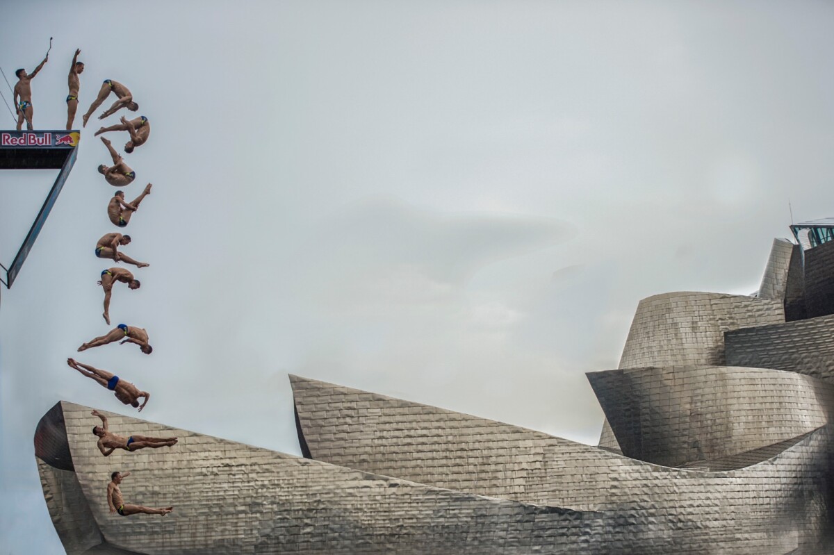 The diver from the Czech Republic, Michal Navrátil, makes one of his jumps next to the Guggenheim Bilbao, as part of the RedBull Cliffdiving world series 2018