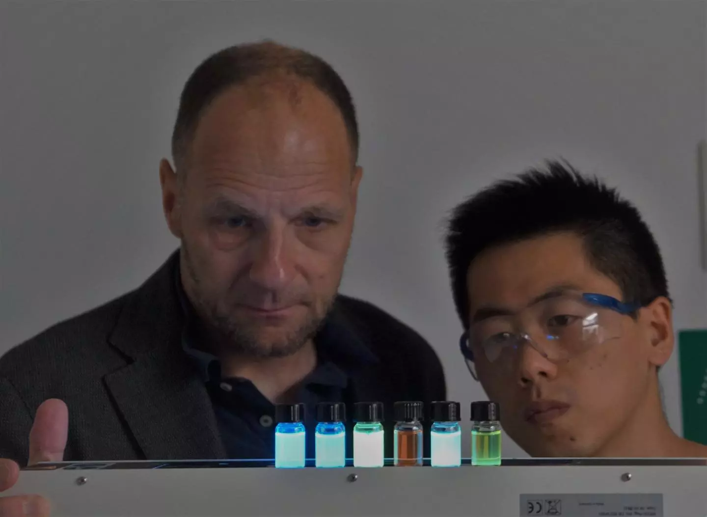 Prof. Uwe Bunz (left) and doctoral student Jinsong Han, with a selection of glowing polymer dyes