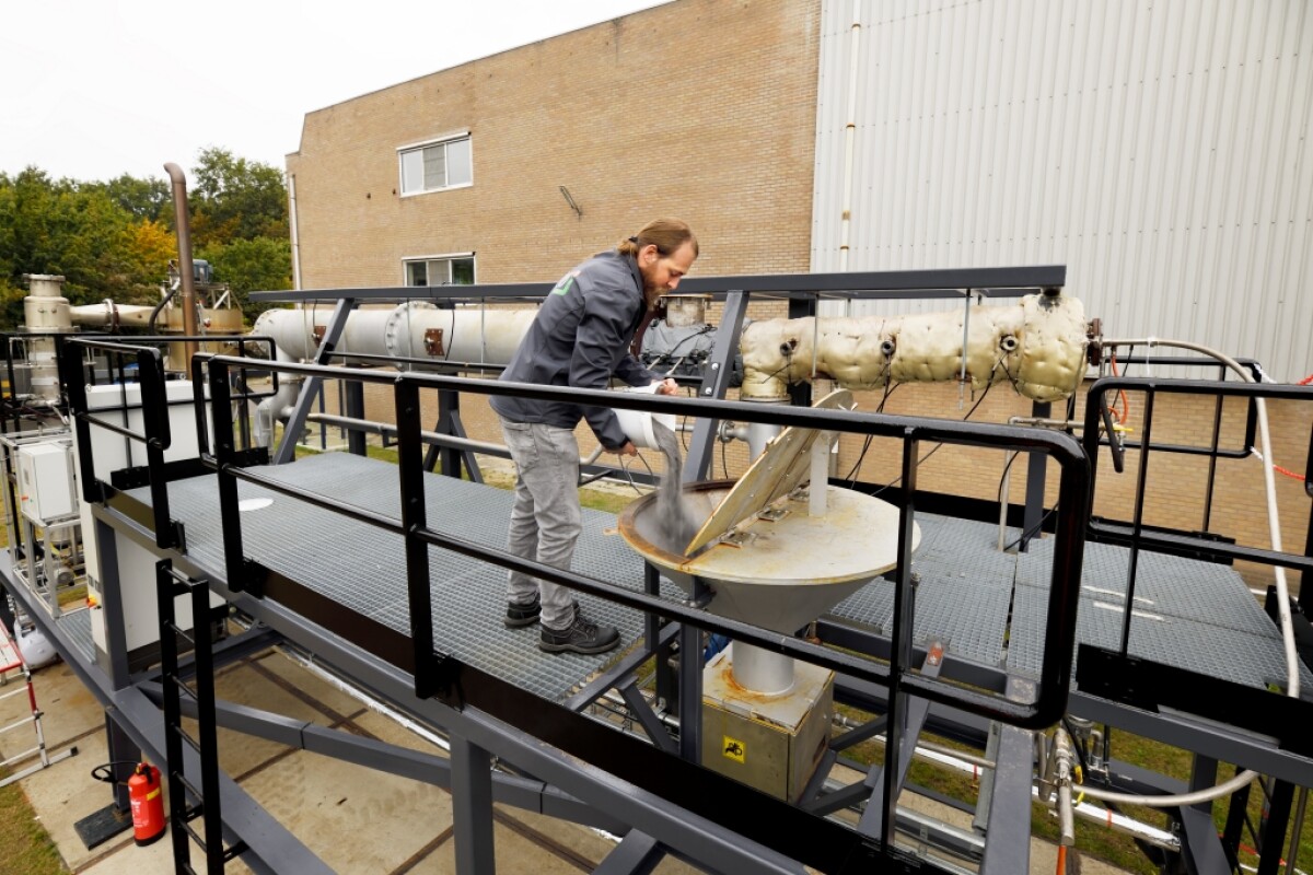 A worker pours iron powder into a funnel to feed a furnace. The Bavaria brewery is now the first business in the world to use metal powder as a clean, sustainable fuel for combustion