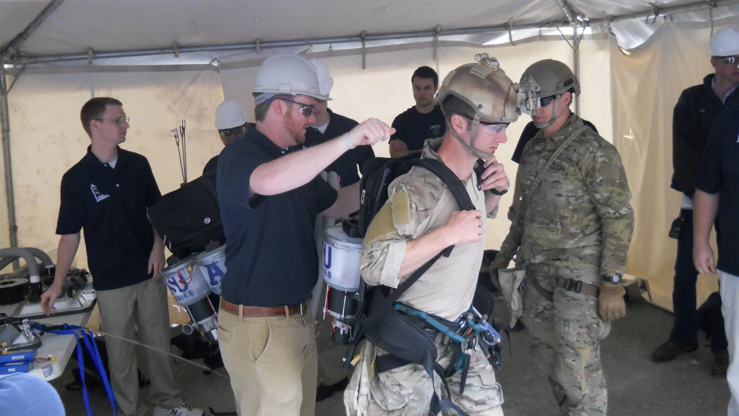 The Utah State University team, suiting up one of the Air Force-supplied climbers (Photo: USU)