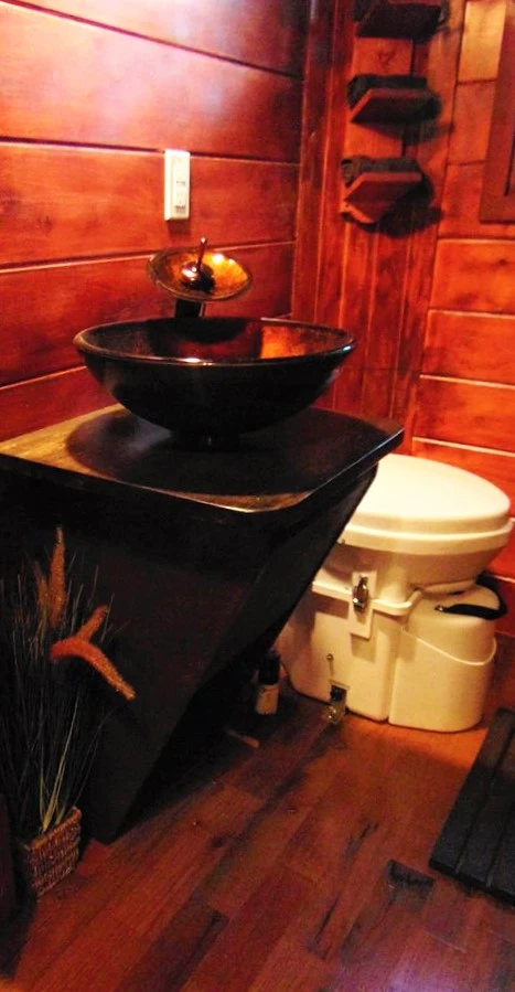 The bathroom includes a composting toilet, sink, and large shower