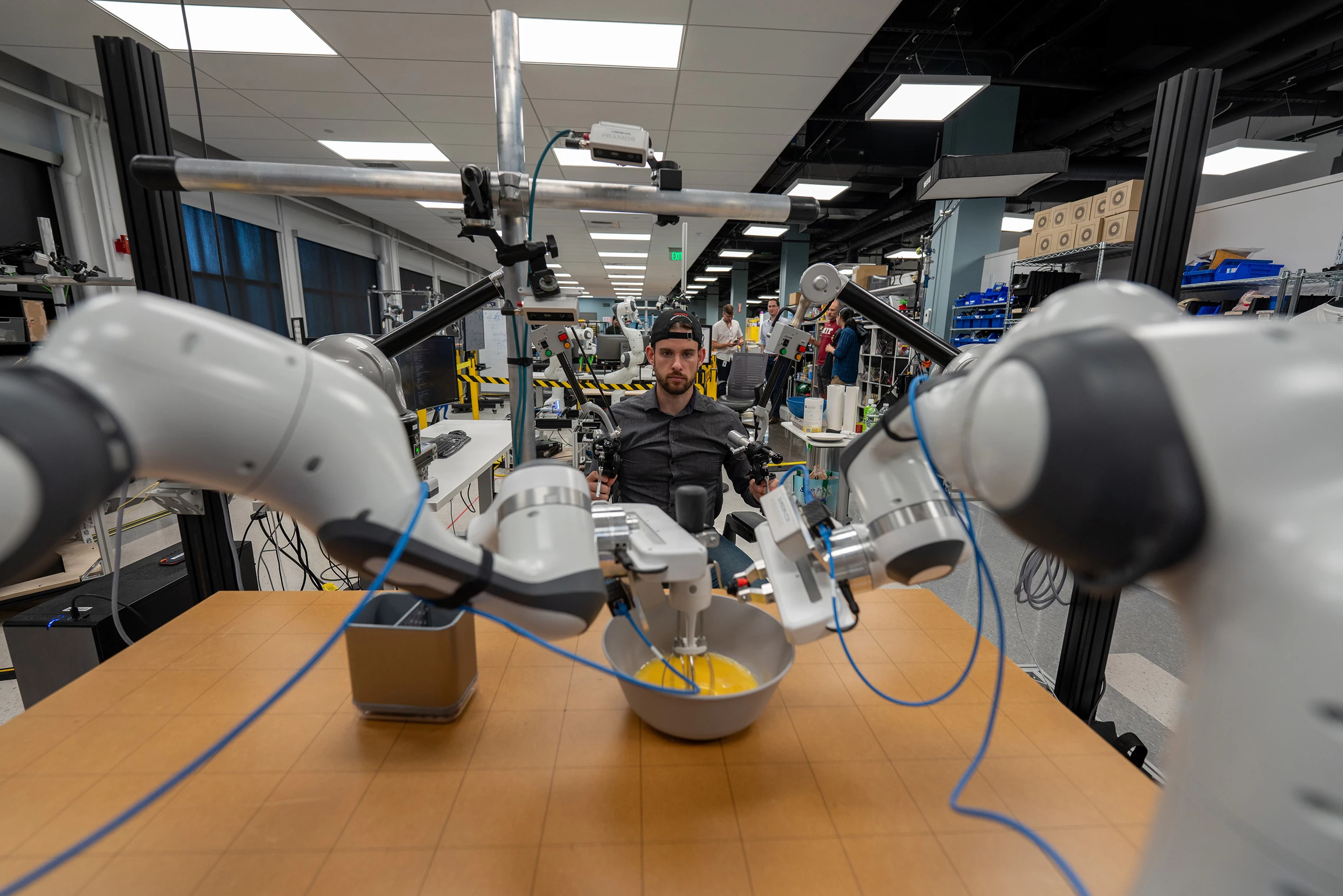 A human operator teaches the bots using haptic controls, then the robot goes away and programs itself how to perform the same task under different and changing conditions