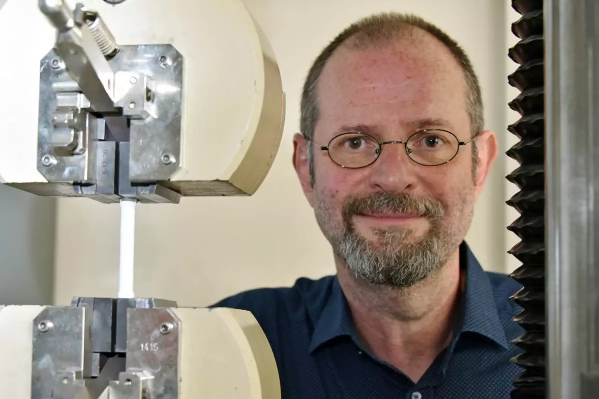 Prof. Frank A. Müller, with a sample of the carbon fiber-augmented calcium phosphate cement undergoing load testing