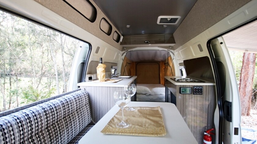 The dining area includes a swivel table and sofa