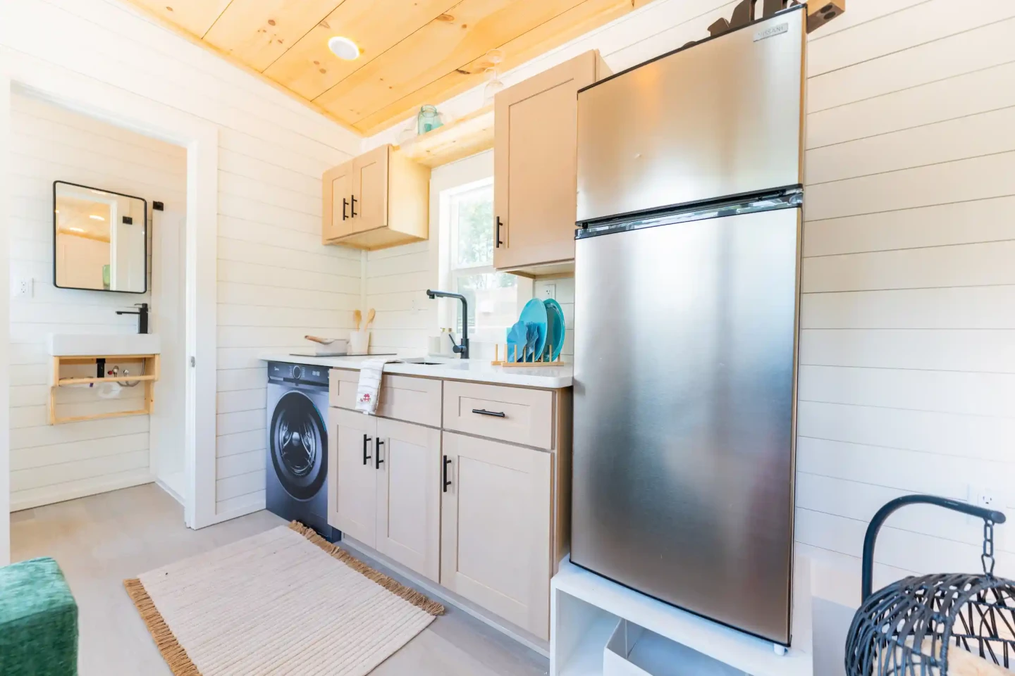 The kitchen in the Fairfax 20' kitchen includes an induction cooktop, a sink, and a fridge/freezer
