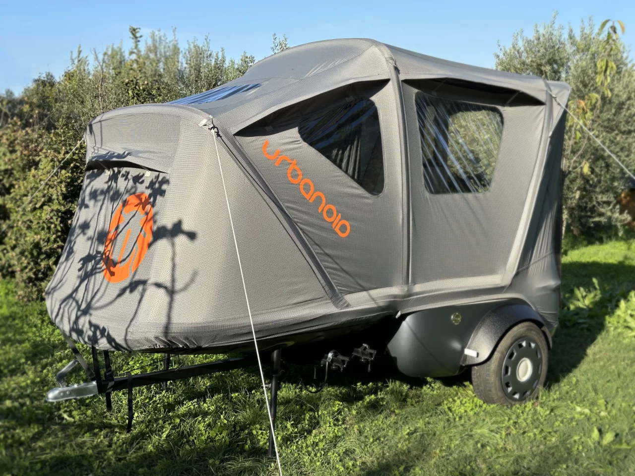 With a fold of the lid, securing of a few straps and guy lines, and inflation by hand or electric pump, the tiny Booba pod becomes a roomy tent