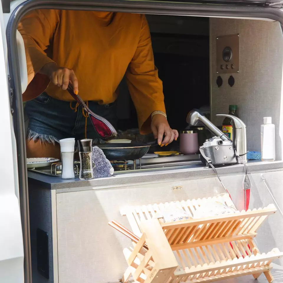 Drop a dish rack on the drop-down outside shelf and wash dishes outdoors