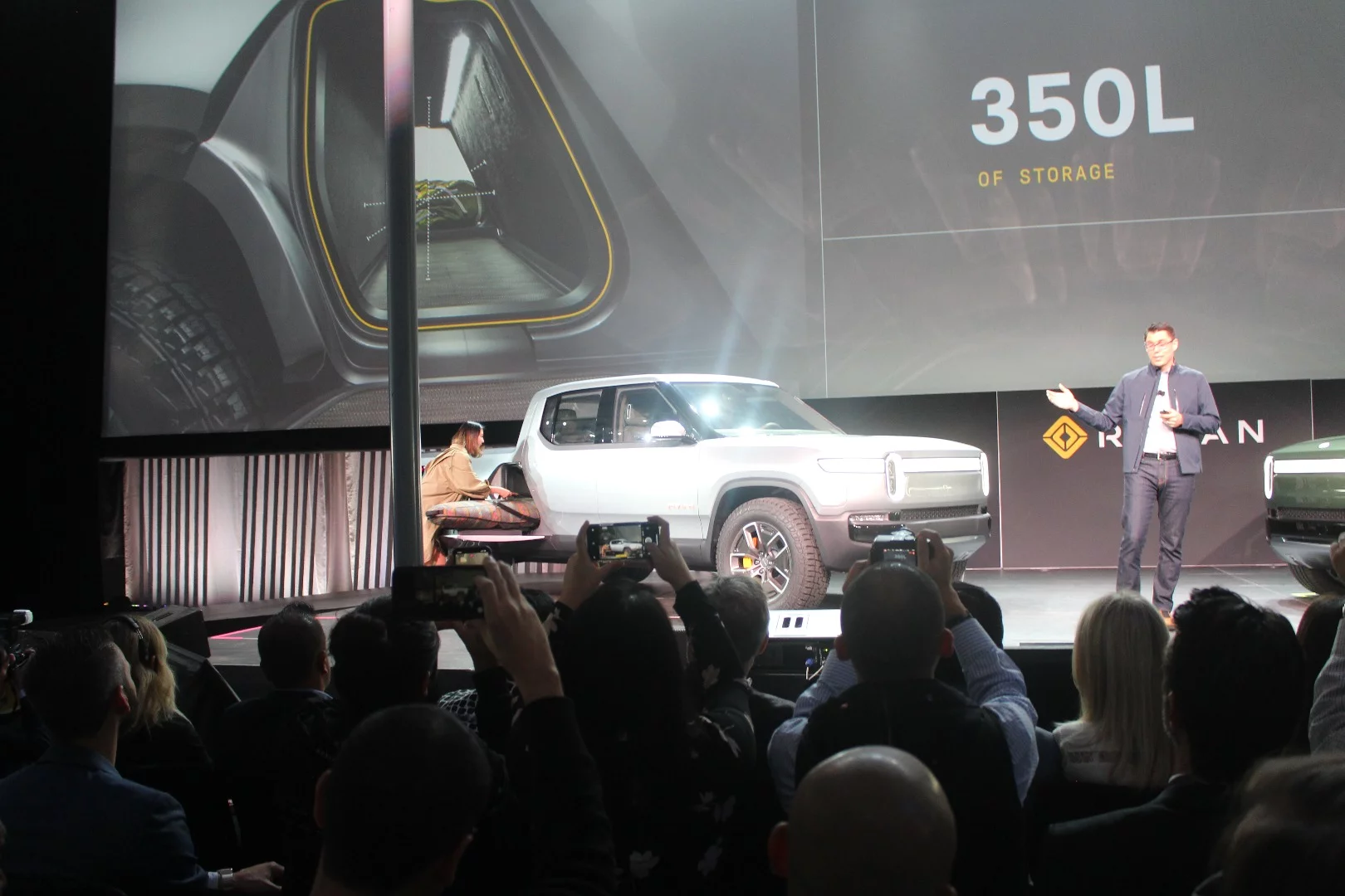 Rivian pulls a snowboard bag out of the rear pass-through tunnel
