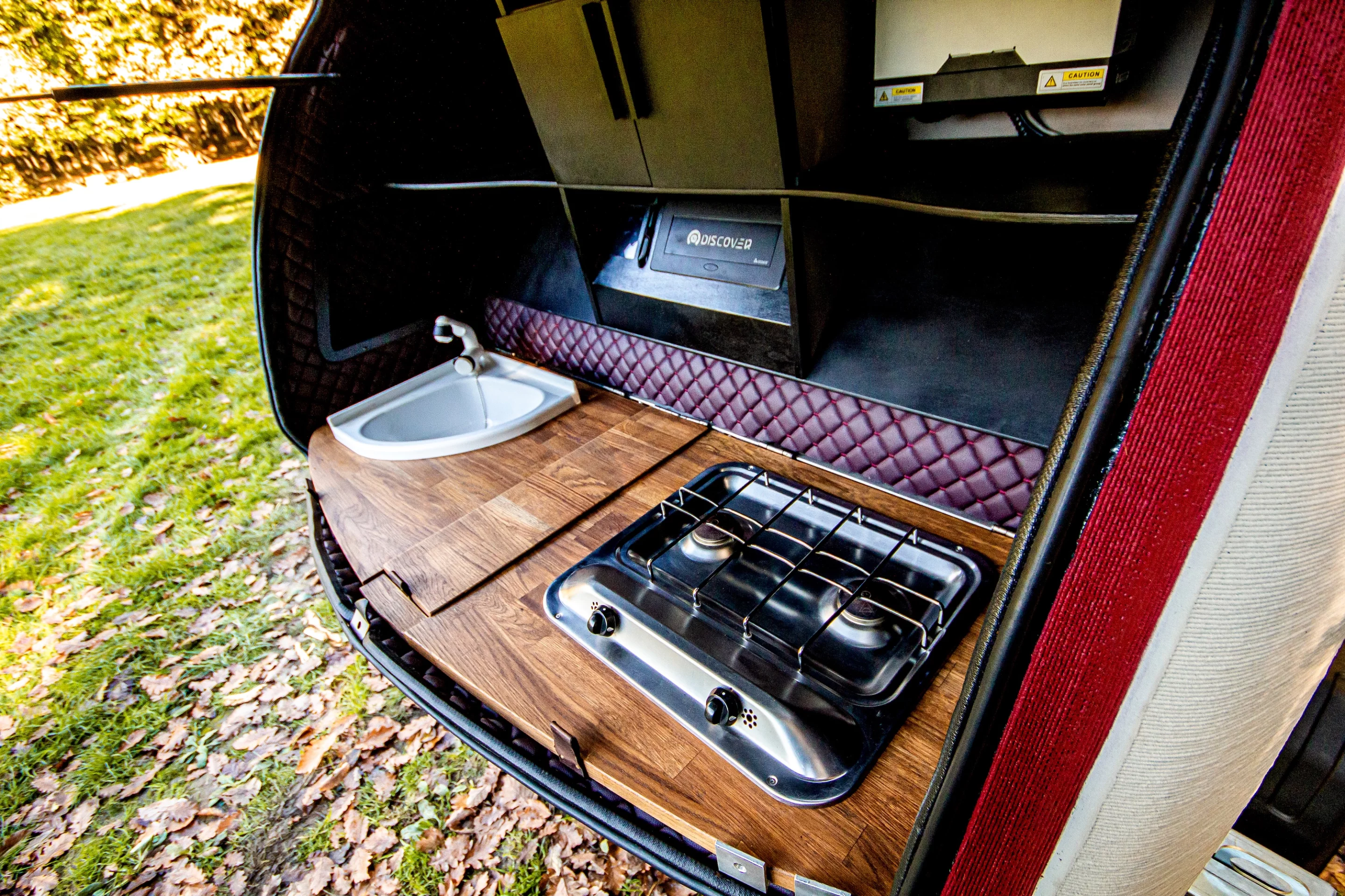 The Discover 3D's tailgate galley includes a small two-burner propane-powered stove and a sink