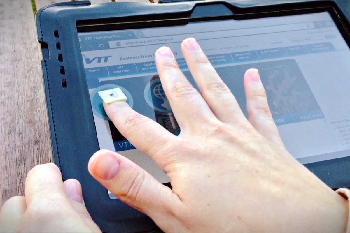 This person uses a fingernail-shaped chip to transfer data between a tablet and a smartphone with just a touch.