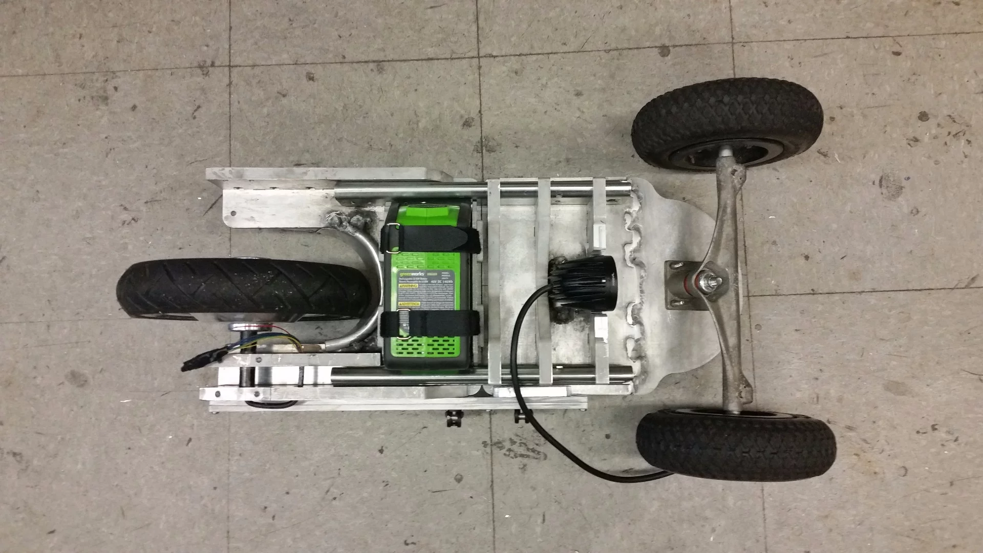 The battery pack is secured in place using Velcro, and there's an LED headlight behind the front trucks of the Mountain-Slider
