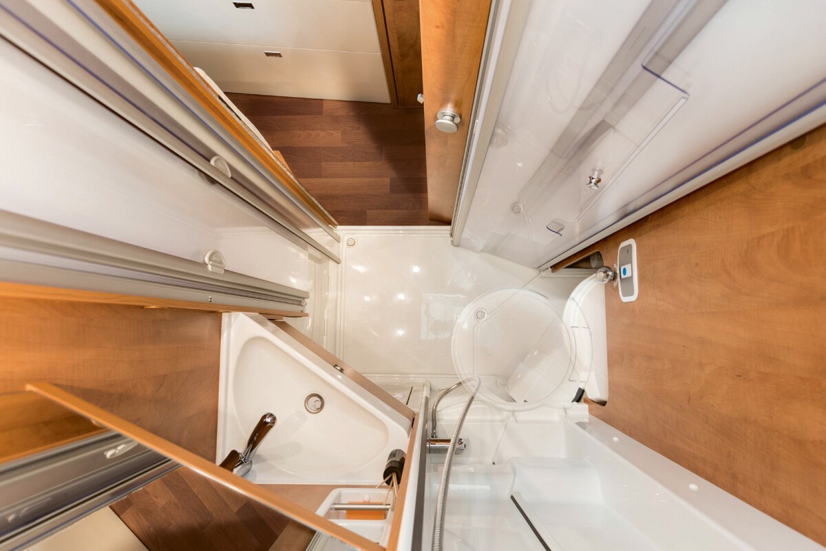 The flexible 3-in-1 bathroom includes a swivel-away toilet and folding shower door, adding a bit of dry bath feel inside the compact wet cell