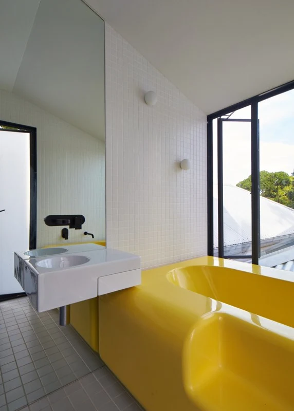 Austin Maynard Architects made its own bath (in bright yellow) using fiberglass that sports no seams