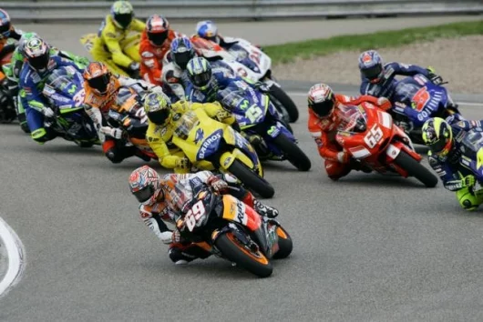 Hayden takes the first race holeshot with Rossi (far right), Barros (4), Capirossi (65), Edwards (5), Gibernau (15), Biaggi (3), Melandri (33), Roberts (obscured), Checa (obscured) and Hopkins (21) in close attendance
