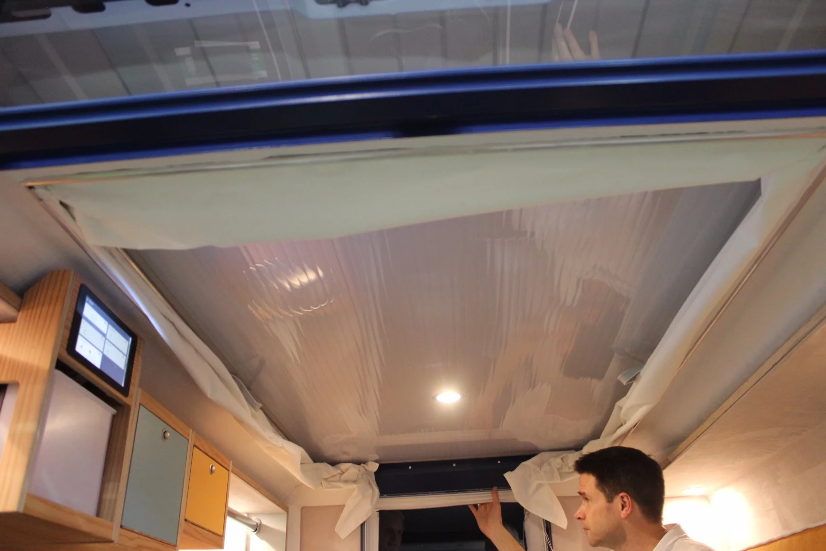 Kortmann demonstrates how the ceiling pulls right down when it's time to break the PlugVan down and remove it from the van