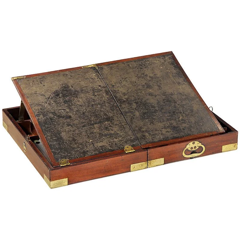 A hinged mahogany box with brass fixtures opened up to reveal a fold-out writing pad on the inside of the lid where the documents were created using special ink