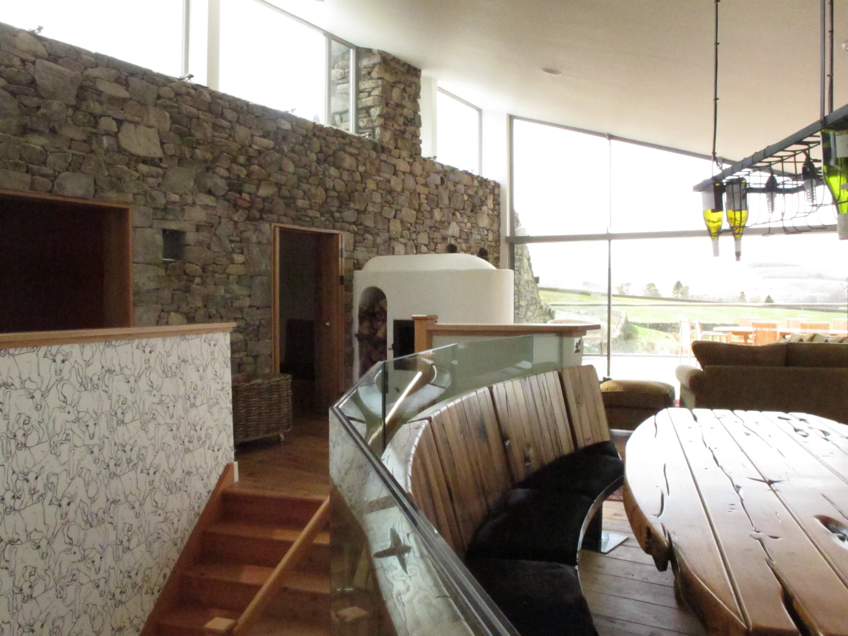 The house is warmed with underfloor heating fed by a ground source heat pump, and supplemented by a wood-burning kachelofen set into a stone wall (Photo: Mark Waghorn Architects)