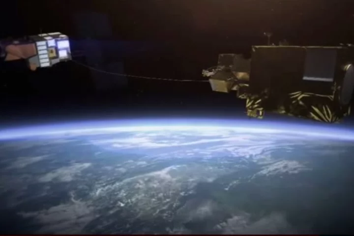 Artist's concept of a derelict satellite being reeled in after being harpooned by the e.DeOrbit satellite (Image: Airbus Defence and Space)