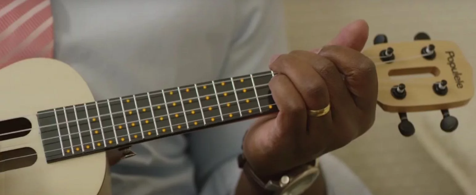 The LEDs embedded in the plastic neck of the Populele can show students where to place fretting gingers, or provide a light show to complement a performance