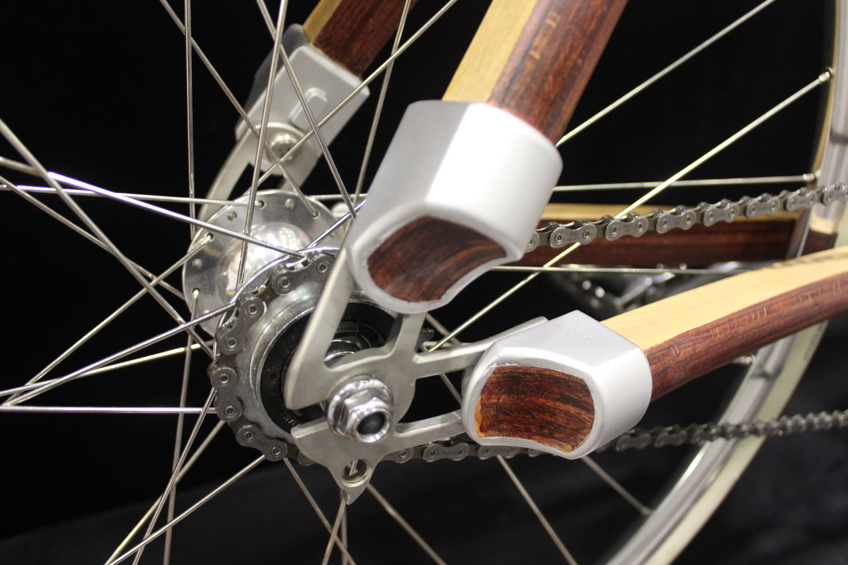 The cast aluminum frame sleeves/rear dropouts on Atelier Kinipio's wooden bike