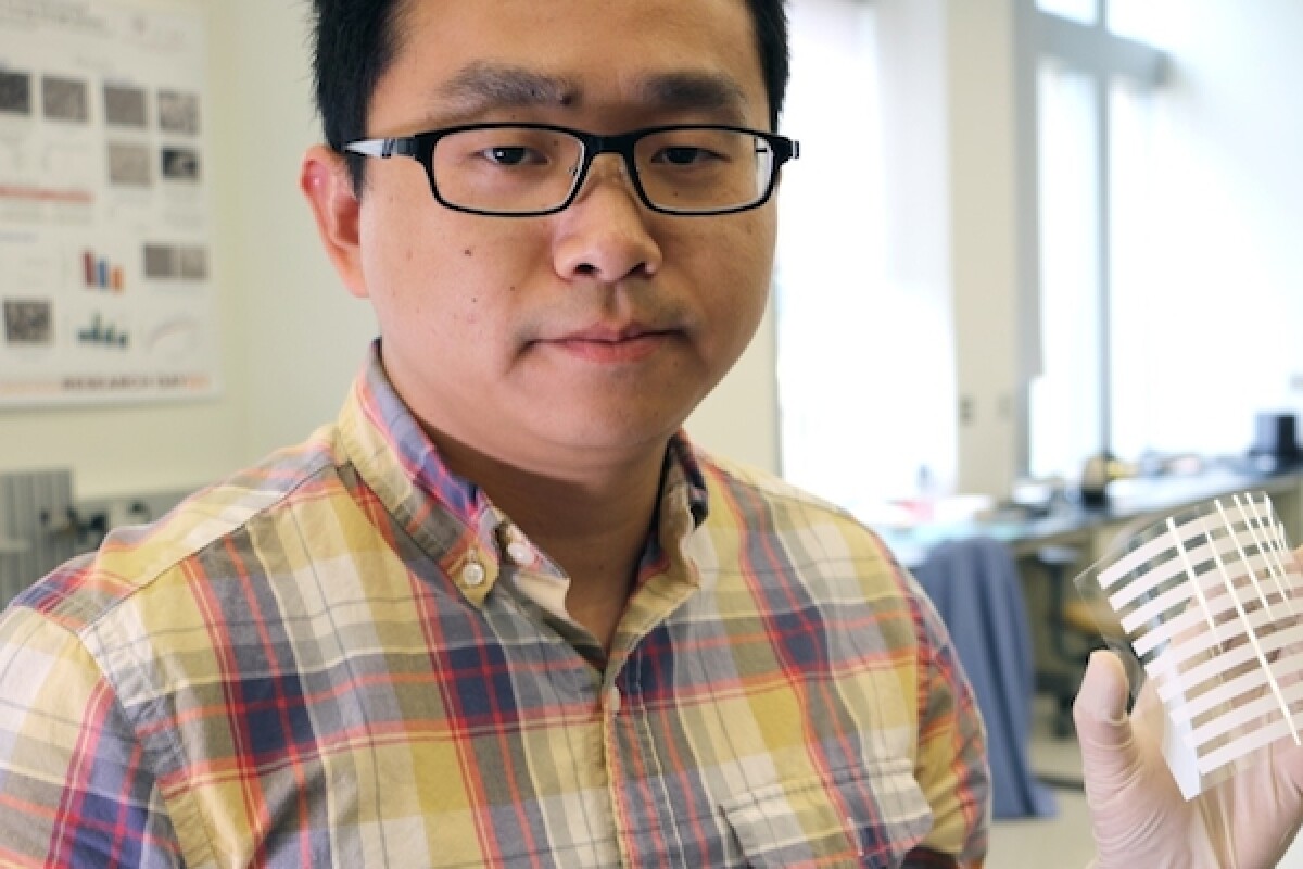 Researcher Congcong Wu, holding up one of the flexible solar tiles that can recycle artificial light