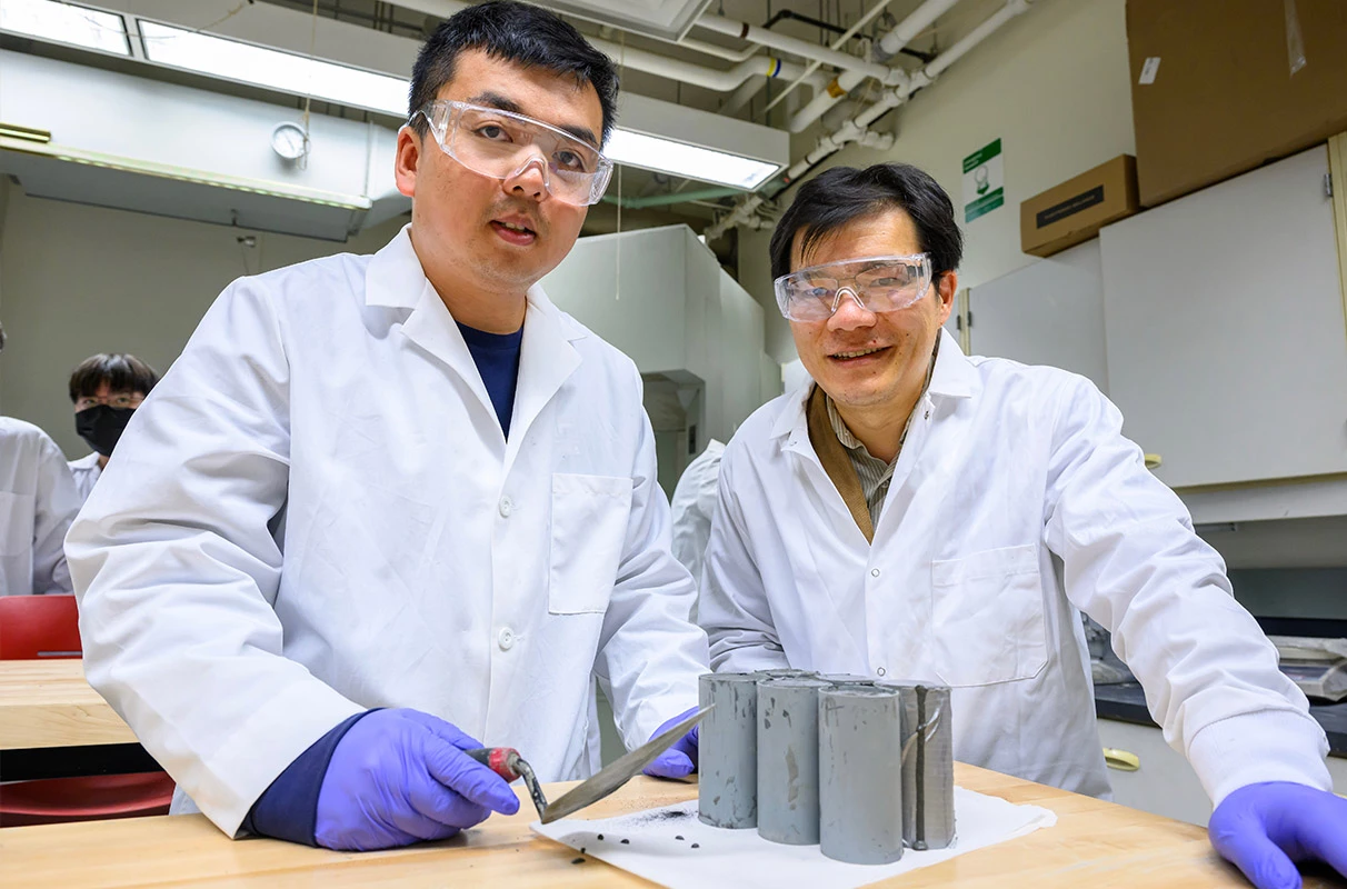 Researchers Zhipeng Li and Xianming Shi with samples of the new carbon-negative concrete