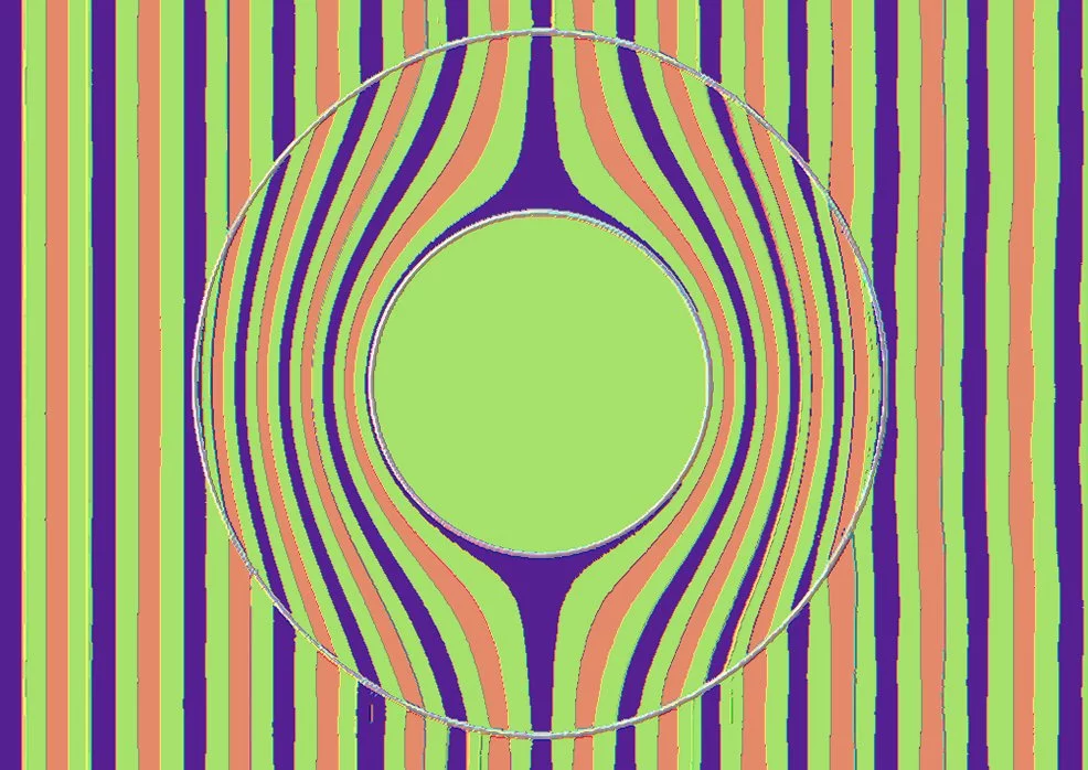 Wavefronts of a beam of light passing through an invisibility cloak; the red lines indicate the largest positive electric field intensity, and the blue lines the largest negative fields, while lime green indicates regions having little or no electric field. (Image: B. Dodson)