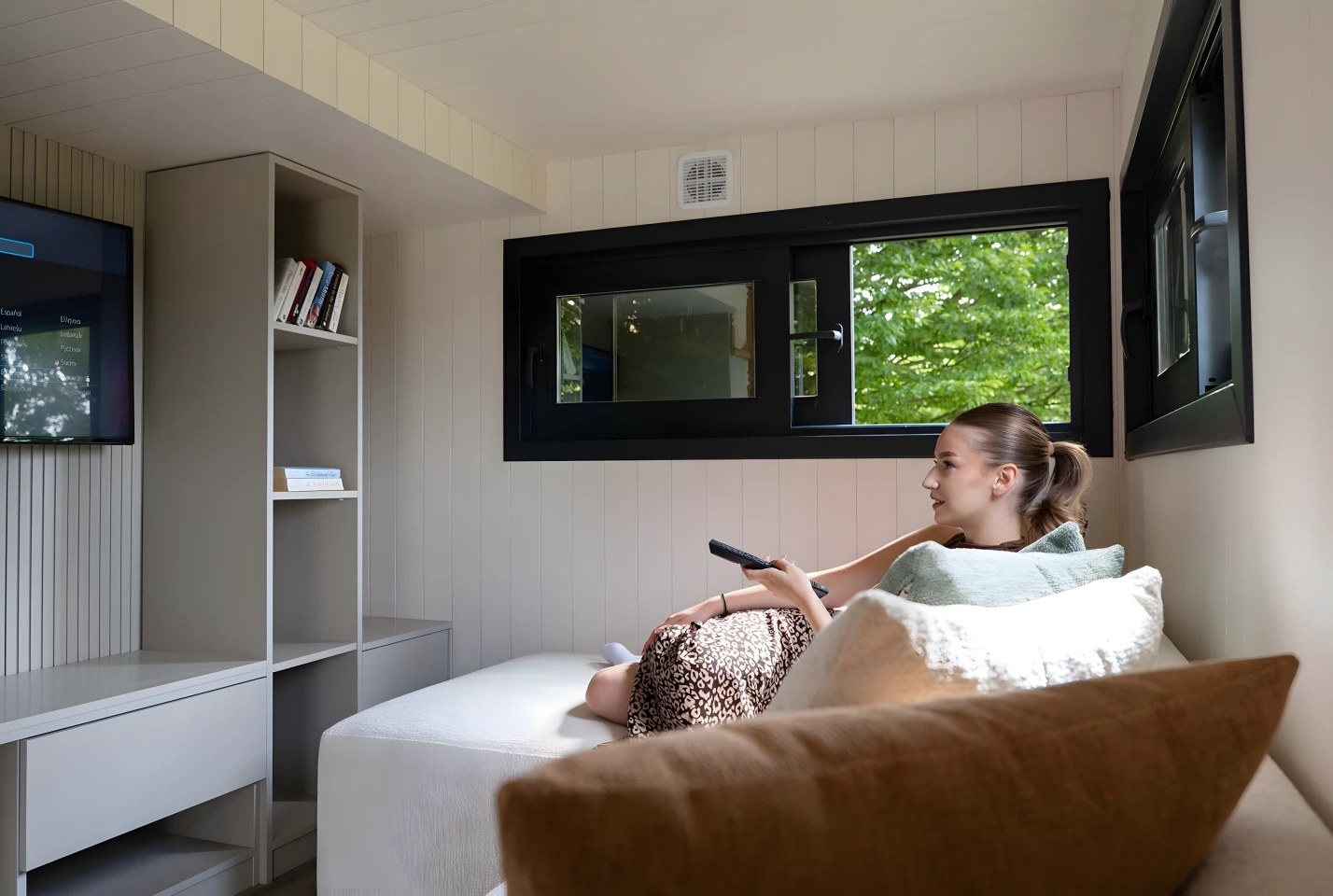 The Miami tiny house's living room contains an entertainment center and a sofa that can be exchanged for a sofa bed to boost sleeping capacity to six