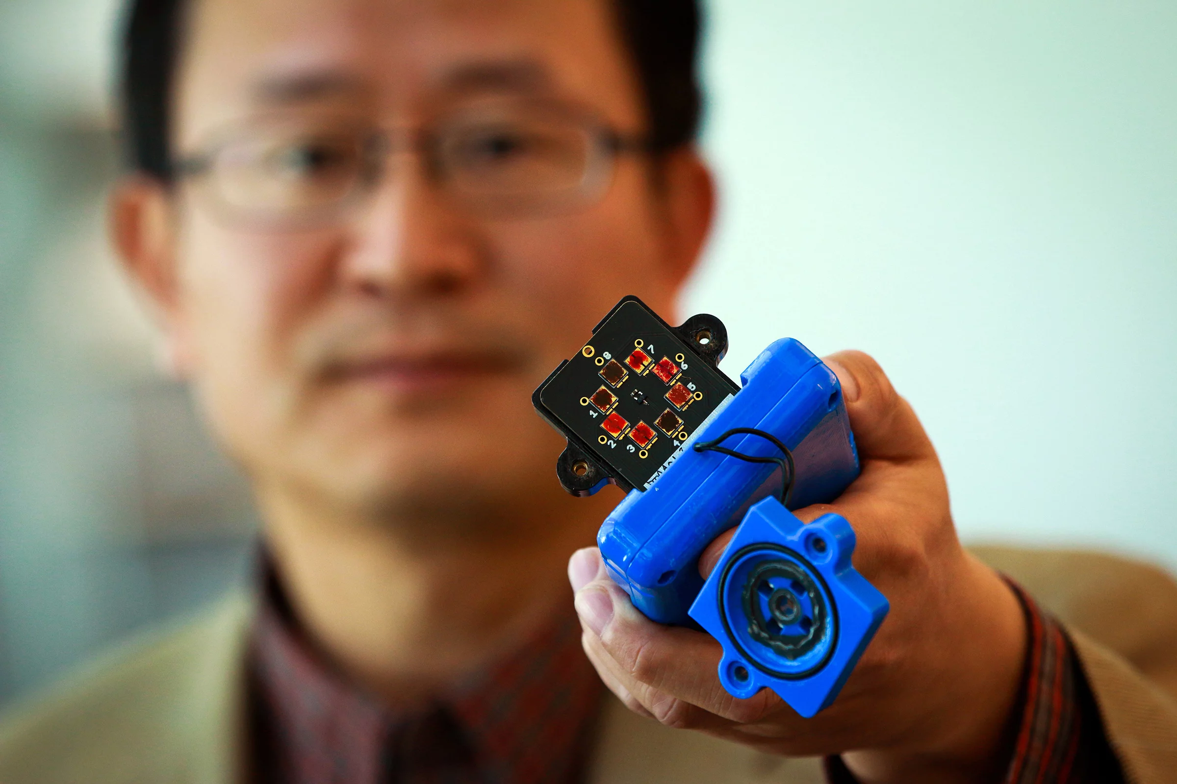 Ling Zang with his prototype explosives sensor (Photo: Dan Hixon, University of Utah College of Engineering)