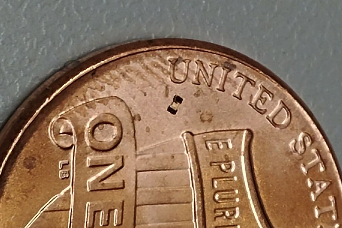 The tiny magnetic robot developed at Purdue University, seen beneath the "U" on this US penny