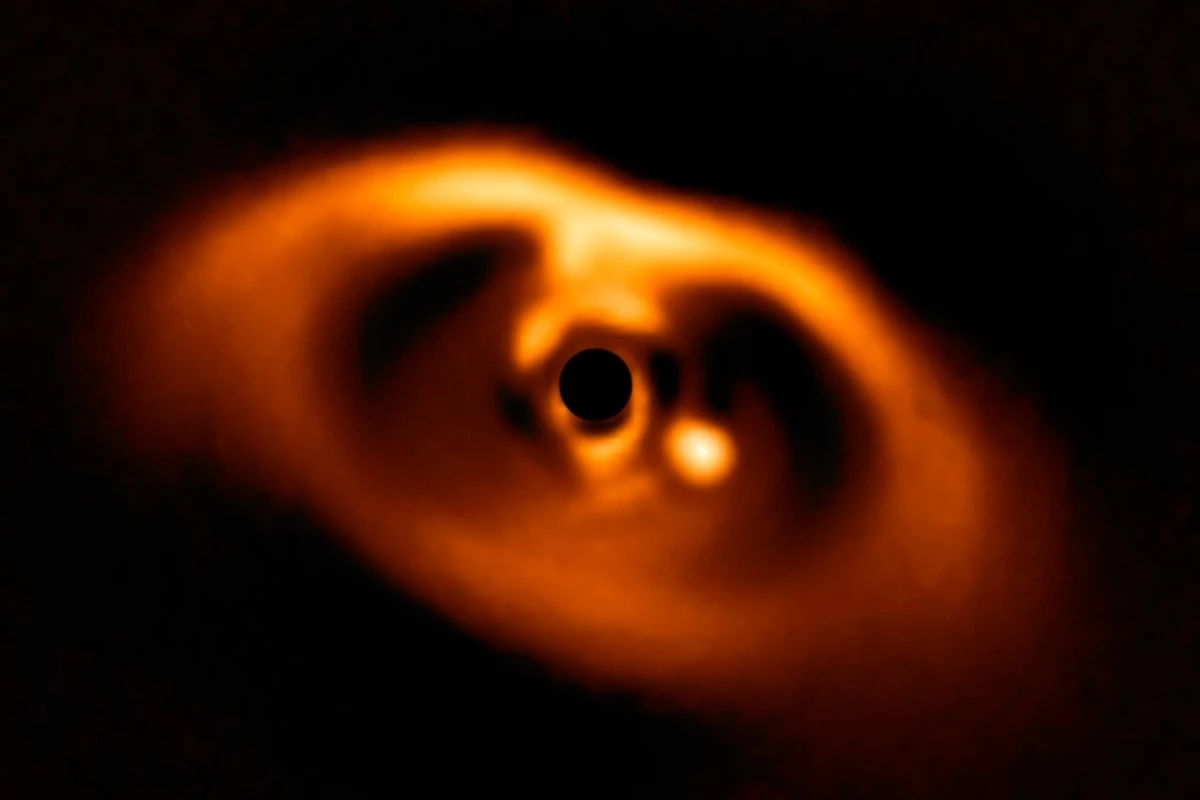 Astronomers have snapped the first confirmed image of a planet still in the process of forming, seen clearly as the bright splotch just to the right of the center of the image