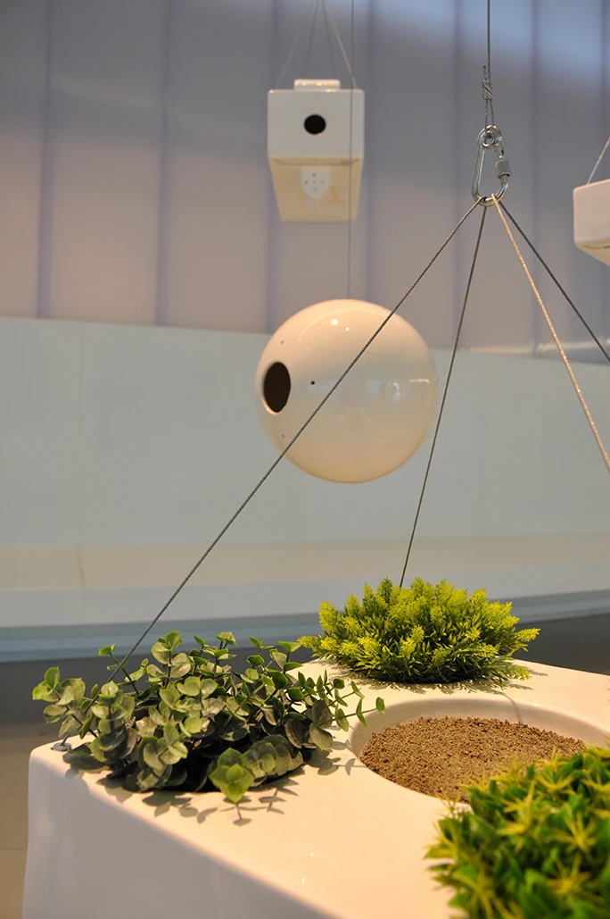 Brazil's interior gallery space is filled with hanging plants, resembling hundreds of different birdhouses