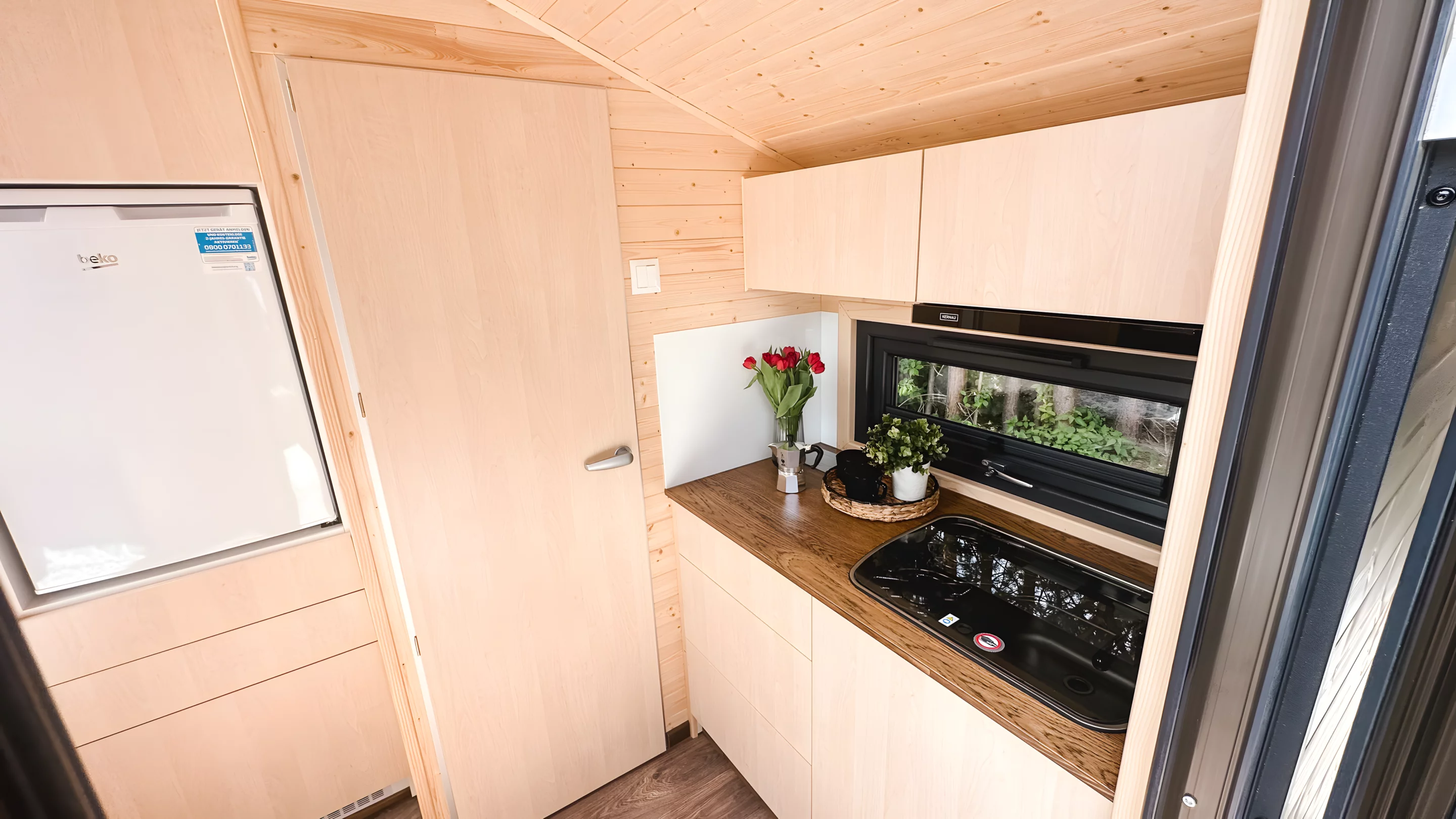 The Honey 216's kitchen includes a propane-powered two-burner stove and a small fridge