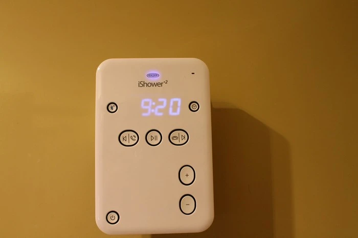 Features include clock, speakerphone and play, volume and track control