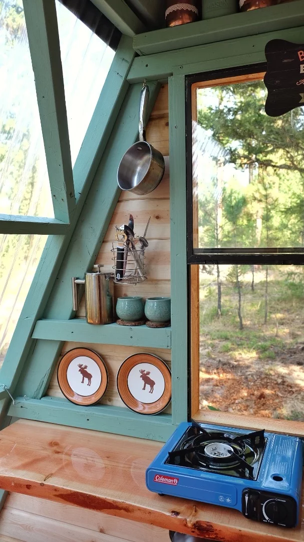 A camping stove and some utensils serve as a basic kitchenette