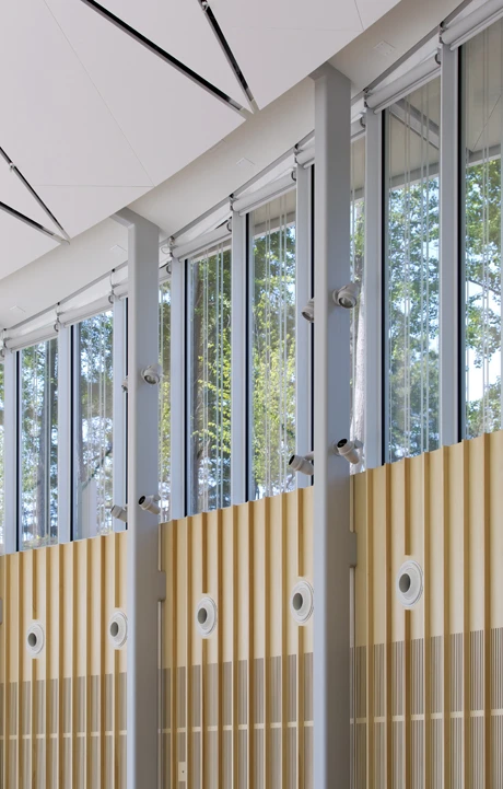 Fritted curved glass walls of the center offer visitors consistent views of the surrounding garden landscape